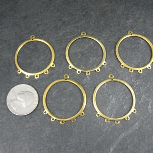 Puede incluir: Cinco aros de pendientes de metal color lat&oacute;n con peque&ntilde;os bucles para sujetar cuentas o abalorios. Cada aro tiene un peque&ntilde;o bucle en la parte superior para colgar. Una moneda est&aacute; al lado de los aros para comparar el tama&ntilde;o.