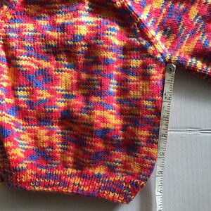 This jumper/sweater fits a 20 inch chest or a 9 month 18 month old. It is knitted in variegated yarn of red, blue and yellow. image 6