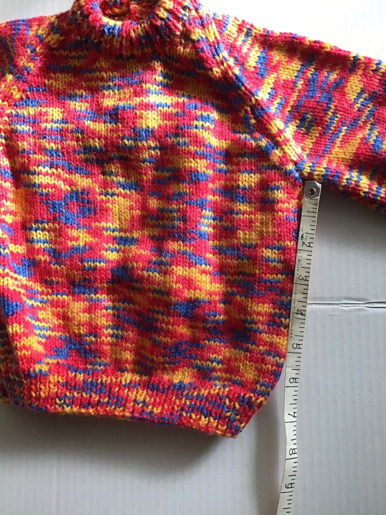 This jumper/sweater fits a 20 inch chest or a 9 month 18 month old. It is knitted in variegated yarn of red, blue and yellow. image 6