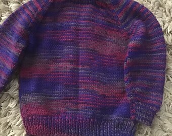 This sweater fits a 20 inch chest or a 1 year old and is knitted in multi colours of royal blue, maroon and grey.