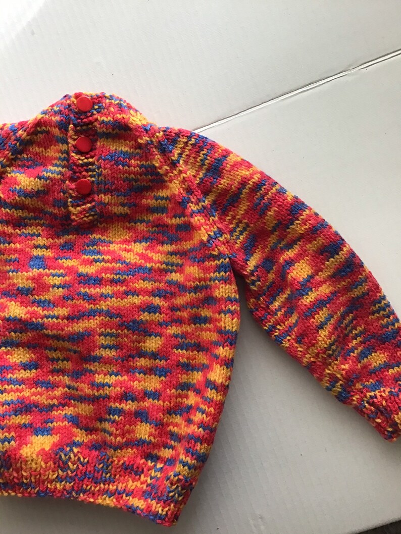 This jumper/sweater fits a 20 inch chest or a 9 month 18 month old. It is knitted in variegated yarn of red, blue and yellow. image 3