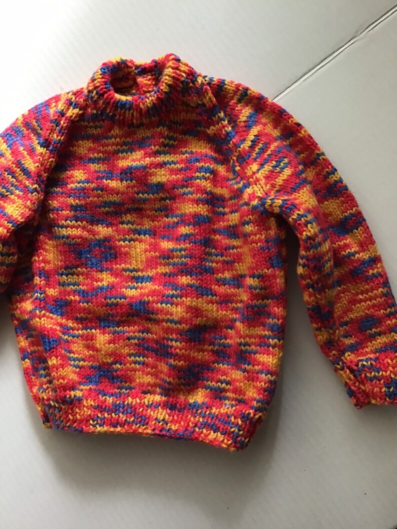 This jumper/sweater fits a 20 inch chest or a 9 month 18 month old. It is knitted in variegated yarn of red, blue and yellow. image 2