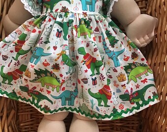 A colourful white Dinosaurs Christmas dress and matching panties to fit a 16 inch Cabbage Patch Doll.