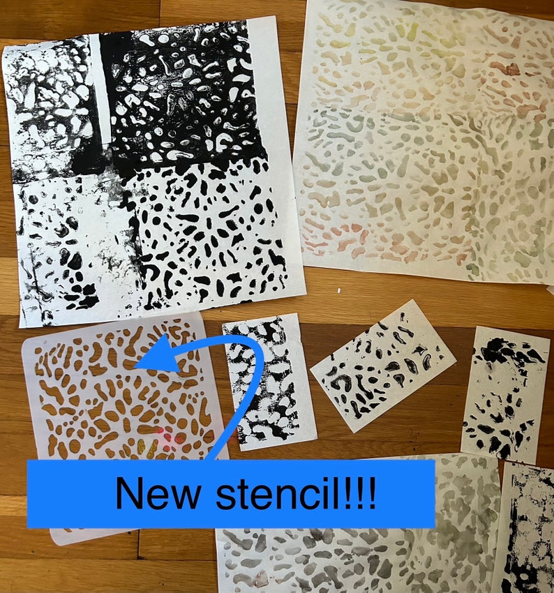 May include: A close-up of a new stencil with a black and white abstract pattern. The stencil is on a wooden surface with several pieces of paper with black ink prints of the same pattern. The text "New stencil!!!" is written on a blue rectangle.