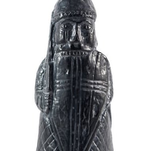 May include: A dark grey chess piece depicting a bishop with a pointed hat and a shield. The piece is made of a textured material and has a detailed design.