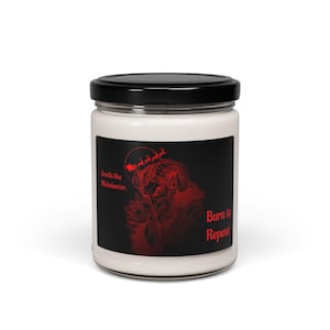 Puede incluir: Un tarro de vela blanco con tapa negra. La etiqueta presenta una ilustración roja de una figura con cuernos con el texto "Smells like Misbehavior" y "Burn to Repent."