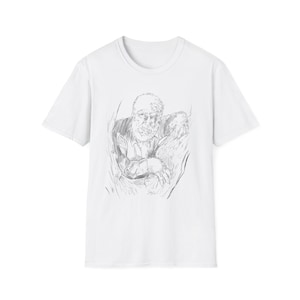 Puede incluir: Camiseta blanca con un boceto a lápiz de una persona mayor con barba. La obra de arte está centrada, mostrando la cara y la parte superior del cuerpo de la persona. La camiseta tiene mangas cortas y cuello redondo.