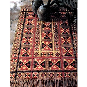May include: A handmade crochet rug with a geometric pattern in red, black, and gold. The rug features a repeating square design with fringed edges. The rug is a warm, inviting home decor item.