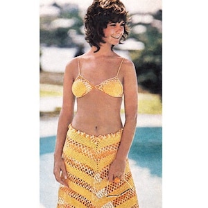 May include: A yellow crochet skirt with a fringe hem. The skirt is made of a lightweight, open-weave fabric and has a chevron pattern.
