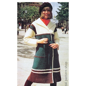 May include: A long, crocheted coat with a wide collar and a belt. The coat is made in a striped pattern of white, brown, and green yarn. The model is wearing a red scarf and a black beret.
