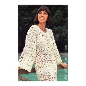 May include: A white crochet dress with a floral pattern. The dress has long sleeves and a loose fit. The model is wearing the dress and smiling.