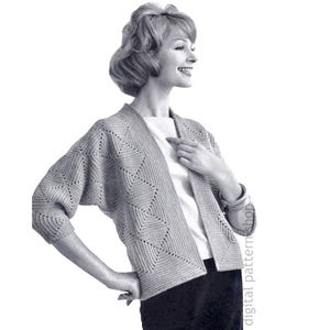 May include: A grayscale image of a knitted cardigan with a geometric diamond pattern. The open-front cardigan has three-quarter sleeves and is worn over a white top. The woman is smiling and wearing a bracelet. The image is from a digital pattern shop.