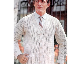 May include: Cream-colored, open-weave cardigan sweater with a V-neck, button closure, and two front pockets. The sweater is worn over a collared shirt and striped tie. The image is a vintage style photograph.
