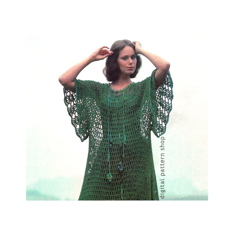 May include: A green crochet dress with a scalloped hem and bell sleeves. The dress is made of a lightweight, open-weave fabric and has a relaxed fit. The model is wearing a necklace with green and blue beads.