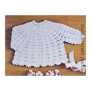 Könnte beinhalten: Ein gehäkelter Baby-Pullover in hellblau mit Knopfleiste. Der Pullover hat einen gewellten Saum und ein zartes Stichmuster.