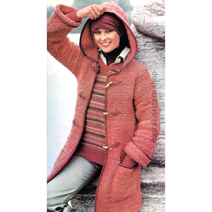 Può includere: Un cappotto di maglia rosa con cappuccio e chiusura a bottoni marroni. Il cappotto ha una maglia testurizzata e un bordo marrone intorno al cappuccio.