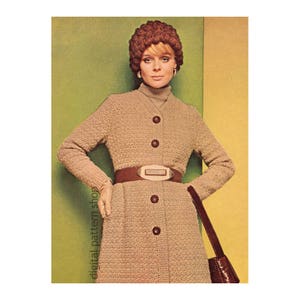 May include: A woman wearing a brown crocheted coat with a brown belt and a brown crocheted hat. She is holding a brown purse.