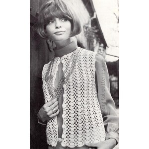 May include: A white crochet vest with a delicate openwork pattern. The vest has a V-neckline and is worn over a white blouse. The model is wearing a silver chain necklace.