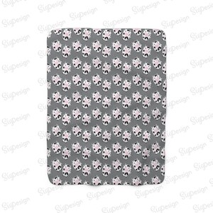 May include: A gray fabric baby blanket with a repeating pattern of black and white cows with pink noses.