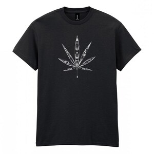 May include: Dark gray t-shirt featuring a white graphic of a cannabis leaf. The leaf design is composed of kayak illustrations. The shirt is made of a soft, comfortable material.