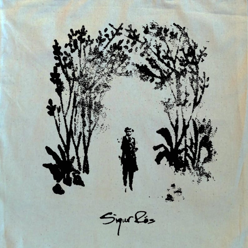 May include: Cream-colored tote bag featuring a black illustration of a person standing beneath an archway of trees and foliage. The text "Sigur R&oacute;s" is written in cursive at the bottom of the image.