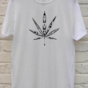 May include: White t-shirt featuring a black graphic of a cannabis leaf. The leaf design is composed of kayak illustrations. The shirt is made of a soft, comfortable material.