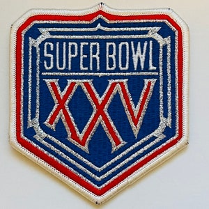 Puede incluir: Un parche del Super Bowl azul y rojo con costuras blancas. El parche presenta el texto "SUPER BOWL" y el número romano "XXV".