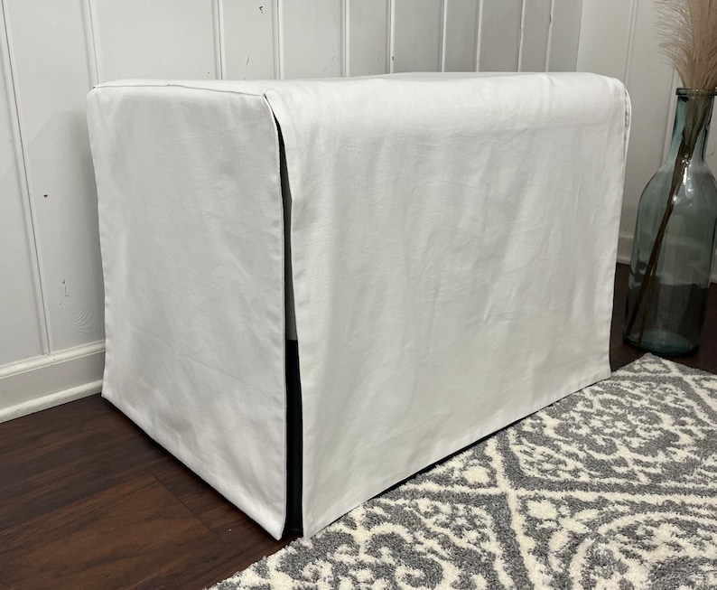 May include: White rectangular dog bed cover with a black trim. The cover is made of a soft, smooth fabric and has a simple, modern design.