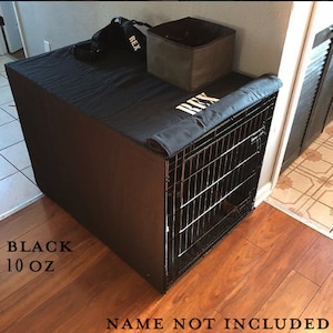 May include: Black dog crate cover with a black fabric flap and the name "REX" embroidered in white. The cover is made of 10 oz fabric.