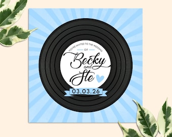 Könnte beinhalten: Eine blaue und weiße Hochzeitseinladung mit einem schwarzen Schallplatten-Design. Der Text lautet "You're invited to the wedding of Becky and Ste 03.03.26".