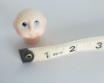 Mini Pink Plastic Bald Baby Head with Blue Eyes (1 Inch)