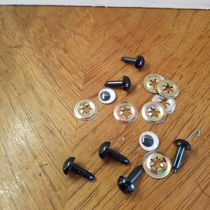 May include: Assortment of black plastic safety eyes with metal washers for crafts. The eyes come in various sizes and are ideal for creating stuffed animals, dolls, and other projects.