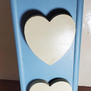 May include: A light blue wooden box with two white heart-shaped cutouts. The box has a hinged lid and a decorative top.