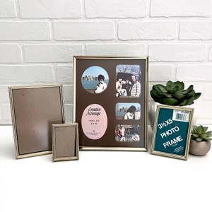 May include: Four silver picture frames with a brown mat and a variety of photos. The largest frame is a collage with a label that reads "Creative Montage" and has an overall size of 8 x 10 inches. The smallest frame is 3 1/2 x 5 inches and has a green mat. The frames are on a white brick background.