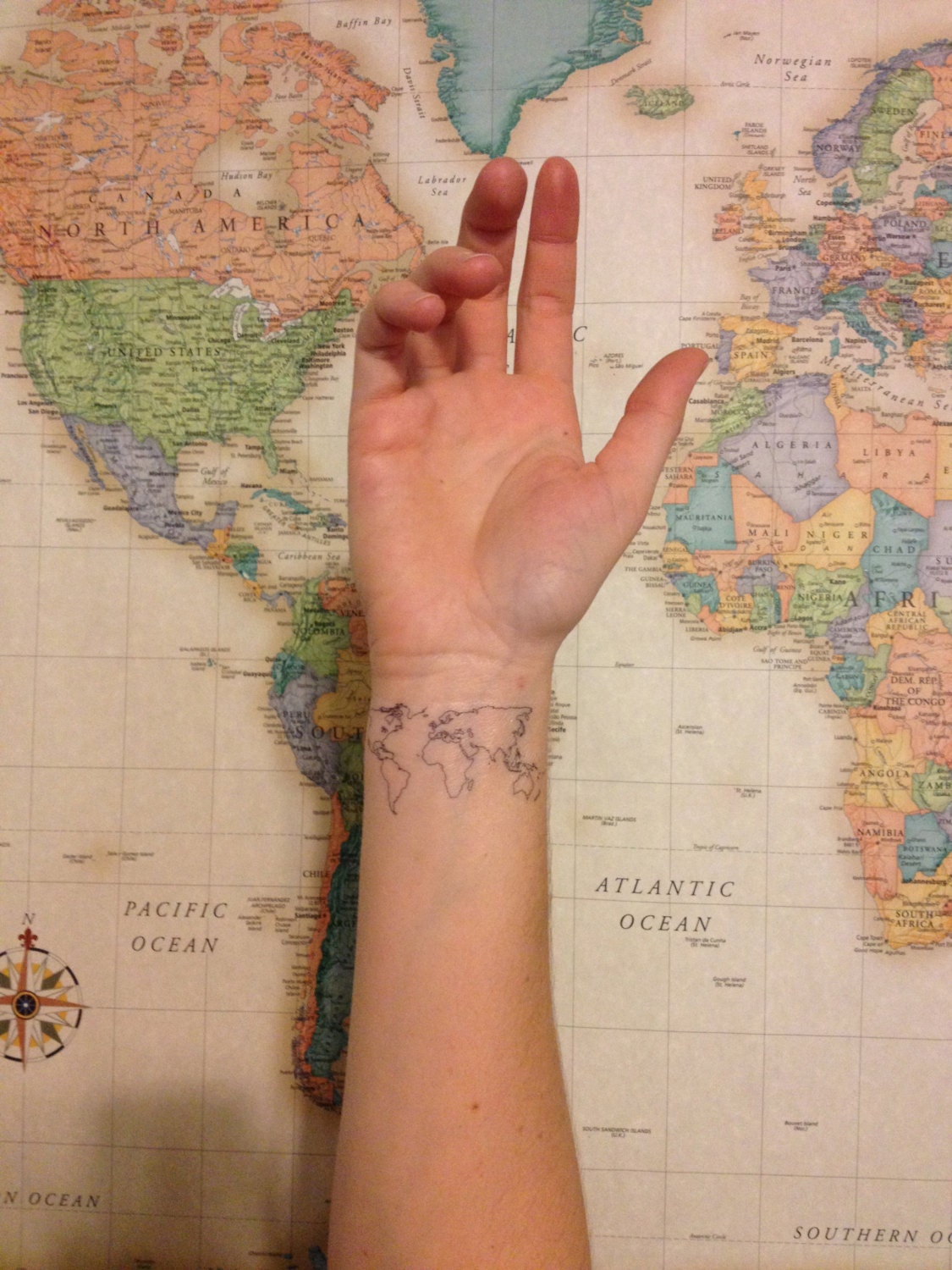 world tattoo on wrist