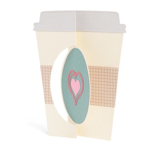Puede incluir: Un vaso de café de papel con un corte ovalado que revela un fondo turquesa con un diseño de corazón rosa.
