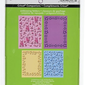 May include: Cuttlebug Emboss Freshly Picked set of 4 embossing folders. The folders feature a variety of designs, including a floral border, a frame with stars, a pattern of trousers and other objects, and a pattern of stars and other objects. The folders are compatible with the Cricut machine.