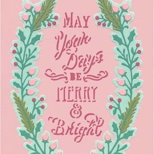 Puede incluir: Tarjeta de felicitación rosa con una corona floral verde y dorada. El texto dentro de la corona dice "May Your Days Be Merry & Bright".