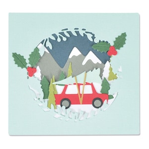 May include: A red car with a Christmas tree strapped to the roof driving through a snowy mountain landscape. The car is surrounded by green trees and holly.