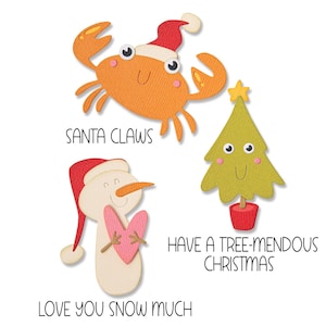Puede incluir: Una tarjeta de Navidad con un muñeco de nieve sosteniendo un corazón, un cangrejo con un gorro de Papá Noel y un árbol de Navidad con una estrella en la cima. El texto dice "Santa Claws", "Love You Snow Much", "Have a Tree-mendous Christmas".