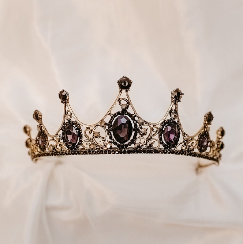 May include: A gold crown with purple gemstones. The crown has a delicate design with intricate details.