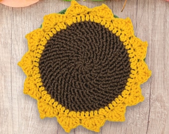 May include: A crocheted sunflower coaster with a brown center and yellow petals. The coaster is made with a textured yarn and has a rustic, handmade look.