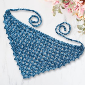 May include: A blue crocheted triangle scarf with two long ties. The scarf is made with a simple stitch pattern and has a delicate, lacy look.