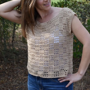 May include: A crocheted top with a loose, open weave and a scoop neckline. The top is sleeveless and has a cropped length. The top is made in a light beige color.
