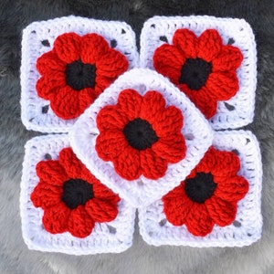 May include: Five crocheted squares featuring red flowers with white centres. The flowers have a raised texture and are surrounded by a white crocheted border.