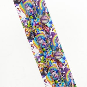 May include: Two pens with a colorful design featuring rainbows, cartoon characters, and vehicles. The pens are on a matching background with the text "SCRIBBLIES and script". The pens have a silver tip and black ink.