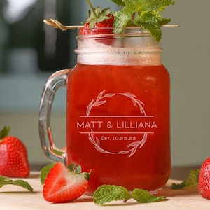 May include: A mason jar filled with a red beverage, garnished with fresh mint and strawberries. The jar has a white inscription that reads "Matt & Lilliana Est. 10.25.22".