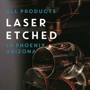 May include: A close-up of a glass being laser etched with the text "ALL PRODUCTS LASER ETCHED IN PHOENIX ARIZONA".