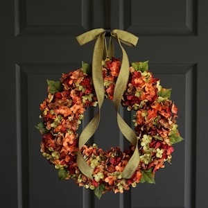 Fall outdoor hydrangea wreath on a black cottage door.