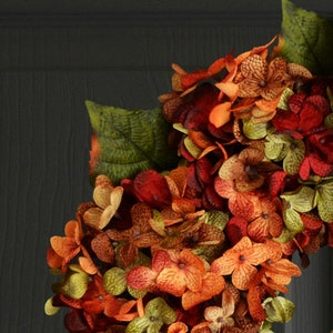 Fall outdoor hydrangea wreath on a black door closeup.